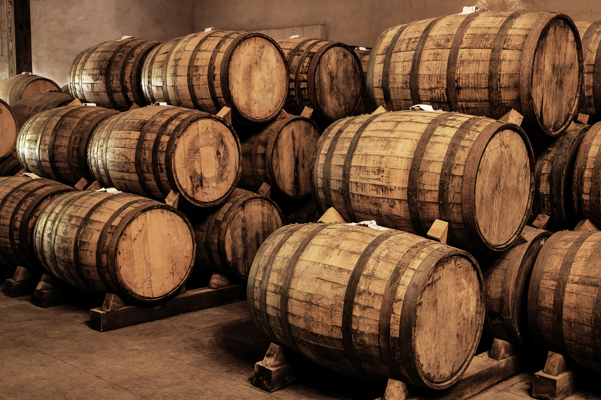 Bourbonfässer Auf dem Bild sieht man liegend gestapelte Bourbonfässer in einem Fasslager.